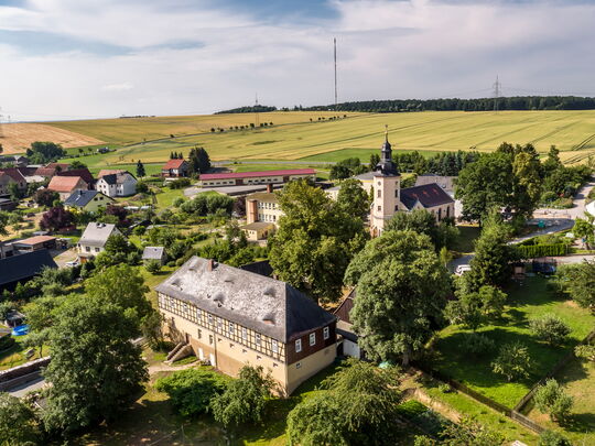 Luftansicht:  Rückersdorf ist umsäumt von Wald und Feldern