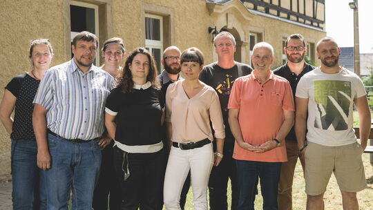 Sozialarbeiter, Heilpädagogen, Psychologe, Erzieher, Arbeitserzieher, Sozialtherapeuten und Ergotherapeuten vor dem Fachwerkhaus, in dem die WG Rückersdorf untergebracht ist.